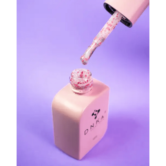 DNKa base gel Lovely roze basisgel fles met kwastje en roze glitterdeeltjes op paarse achtergrond