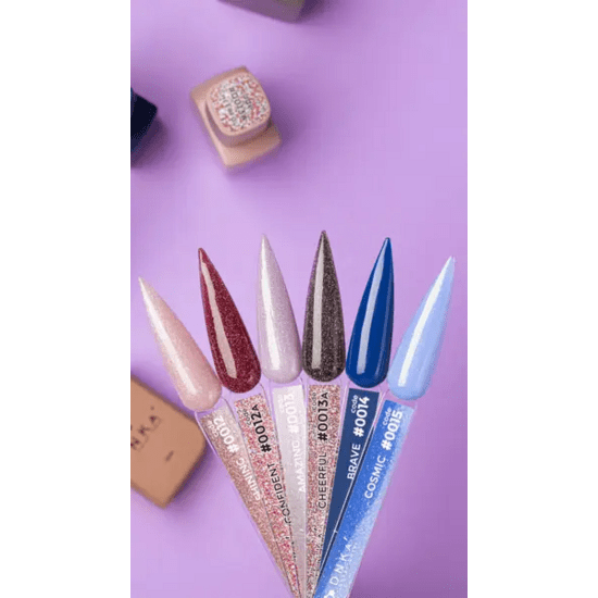 Vijf gekleurde stalen met DNKa Cover Base Brave op paarse achtergrond