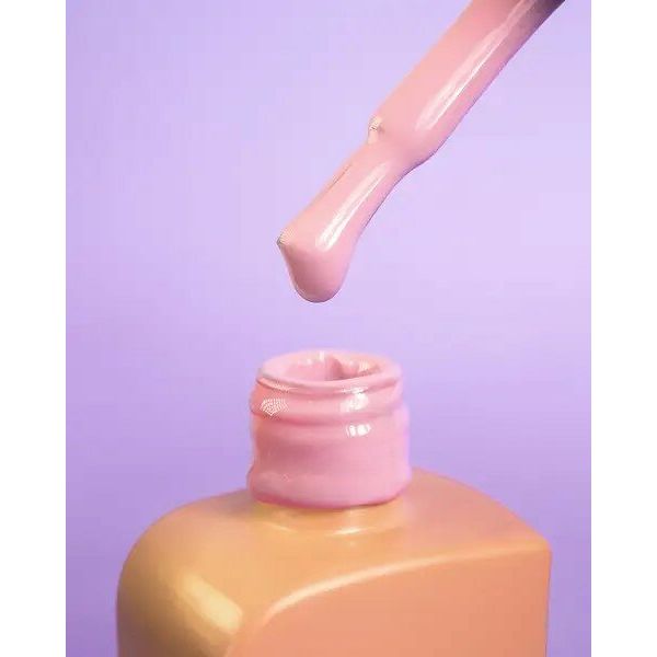 Roze nagellakflesje met druppelende kwast om professionele nagelproducten kopen te promoten