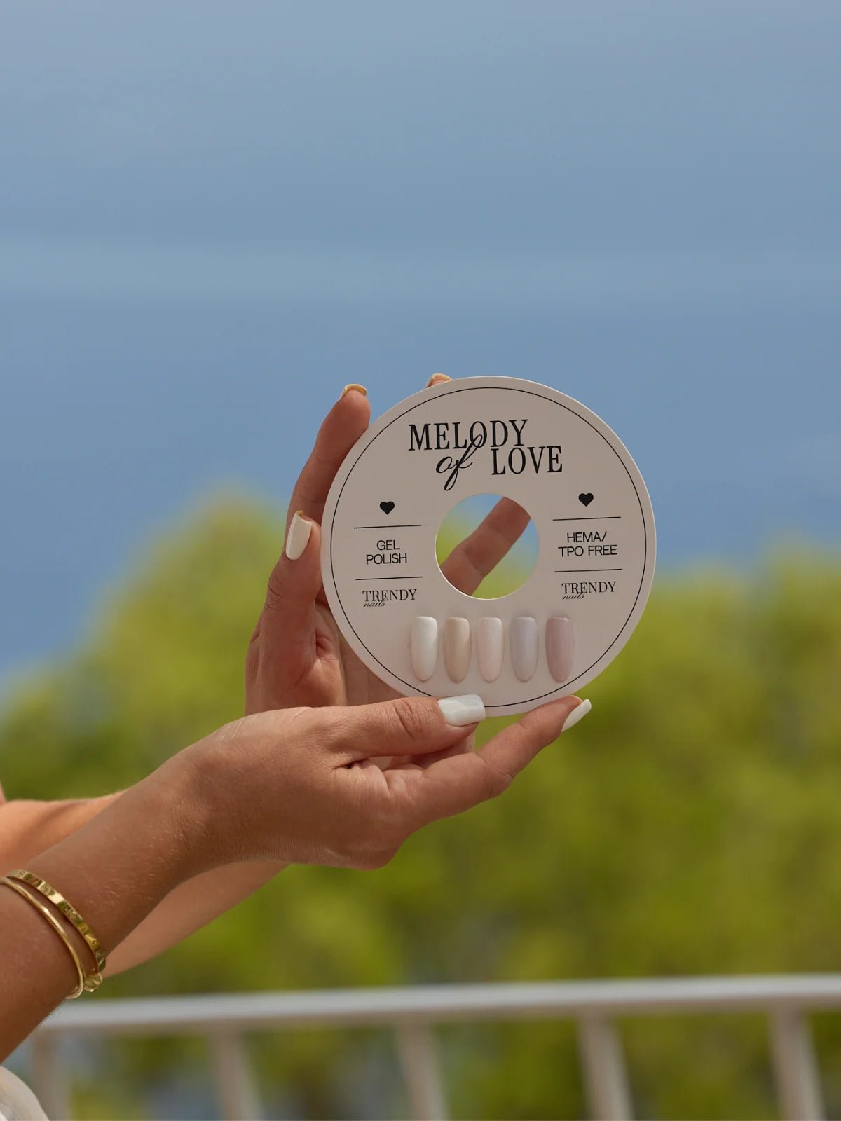 Haar mannelijke hand houdt een gellak Aria 8ml kleurcirkel vast met chic huidskleurige nagels