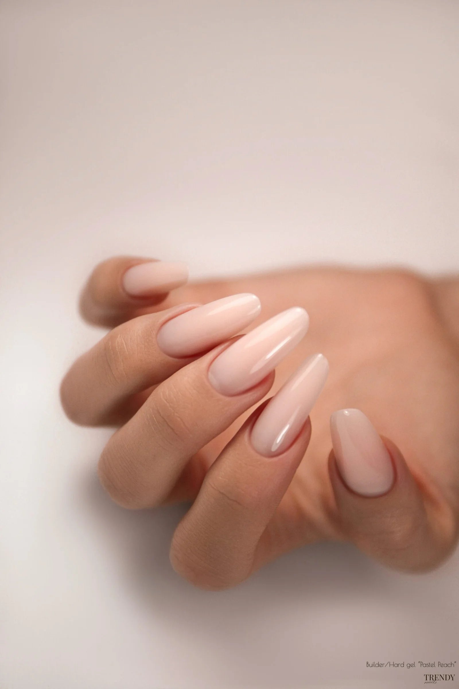 Hand met nagels, gelakt met Trendy Nails builder gel pastel peach voor een elegante uitstraling