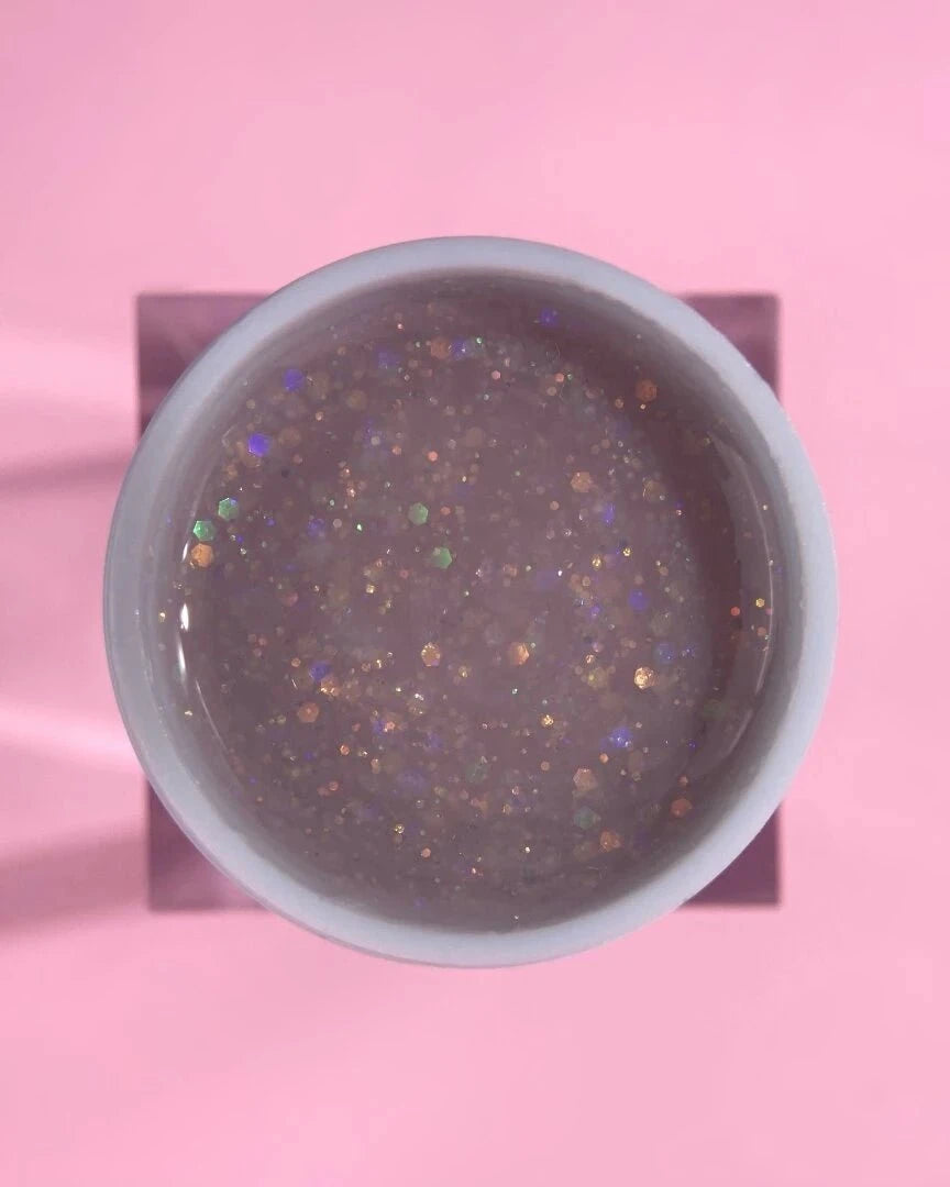 LUNA Diamond Gel in een witte pot met kleurrijke glitters op een roze achtergrond